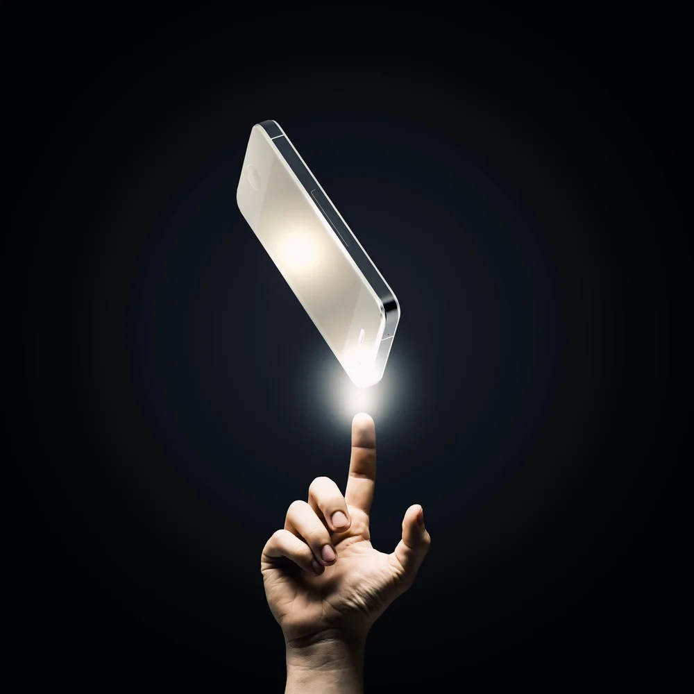 Human hand pointing at mobile phone with finger